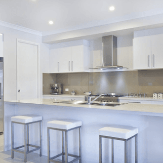 Bright white galley kitchen with island breakfast bar and pendant lighting
