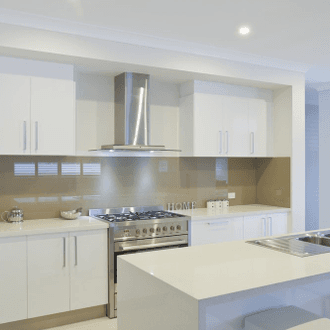 Gloss white kitchen with freestanding gas range and stone-topped island